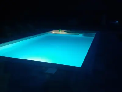 a swimming pool with blue lighting in the dark at Vacation House Studenac in Bihać