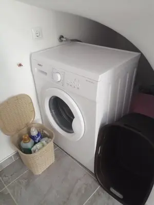 a washing machine in a room with a basket at Vacation House Studenac in Bihać