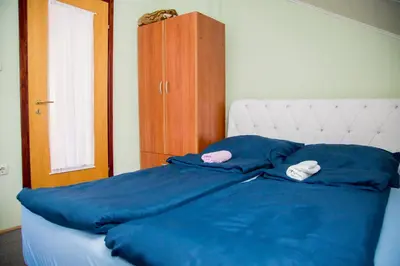 a bed with blue sheets and two white towels on it at Villa Dino in Kulen Vakuf