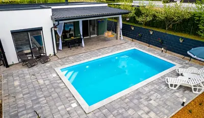 a swimming pool with a patio and a house at simply-una in Bihać