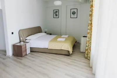a bedroom with a bed and a wooden floor at Hotel Athos in Modriča