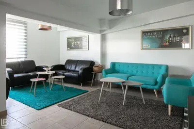 a waiting room with a blue couch and tables at Hotel Athos in Modriča