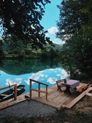 a picnic table on a dock next to a lake at Holiday home Green coast in Bosanska Krupa