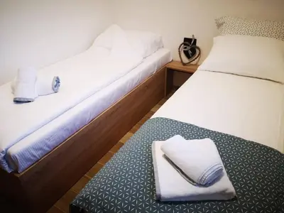 two beds with white towels on a bench in a room at Holiday home Green coast in Bosanska Krupa
