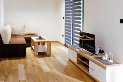 a living room with a couch and a tv at Holiday home Green coast in Bosanska Krupa