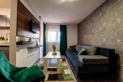 a living room with a blue couch and green chairs at Apartments and Rooms Villa Majestic in Bihać