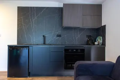 a kitchen with blue cabinets and a black appliance at Apartments and Rooms Villa Majestic in Bihać