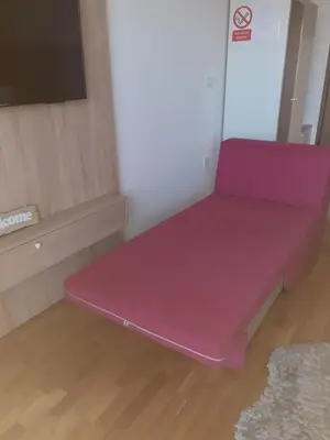 a pink bench sitting in the corner of a room at Apartman Krasula Doboj in Doboj