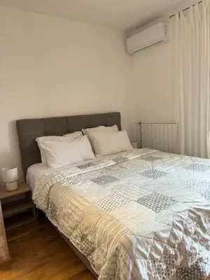 a bedroom with a large bed with a comforter at Apartman Krasula Doboj in Doboj