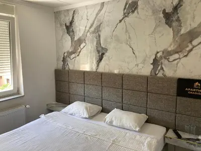 a bedroom with a bed with two pillows on it at Gradiska Pristajko in Bosanska Gradiška