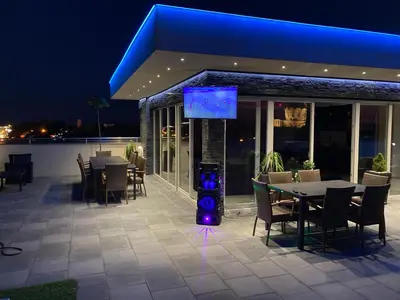 a patio with a table and a tv on a building at Gradiska Pristajko in Bosanska Gradiška