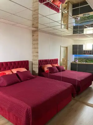 two beds in a room with purple sheets and mirrors at Gradiska Pristajko in Bosanska Gradiška