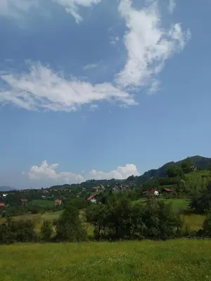 a view of a green field with a blue sky and clouds at Holiday Home Dzeni in Zenica