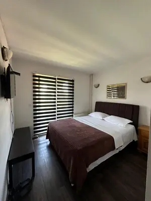 a bedroom with a large bed and a television at Prenoćište SAMIR in Gradačac