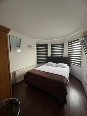 a bedroom with a large bed and two windows at Prenoćište SAMIR in Gradačac