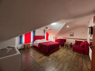 a bedroom with a bed and two red chairs at Prenoćište SAMIR in Gradačac