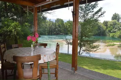 a table on a porch with a view of a river at Villa My Island in Bihać