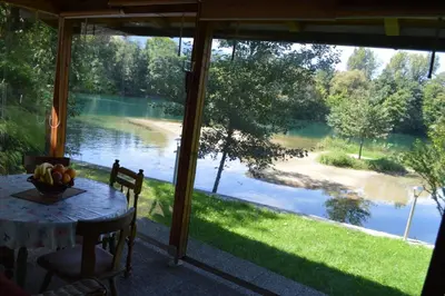 a porch with a table and a view of a river at Villa My Island in Bihać