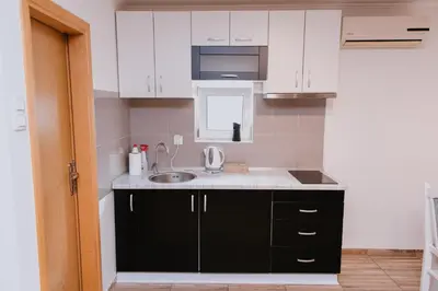 a kitchen with white cabinets and a sink at Studio Apartment Dzungla in Doboj