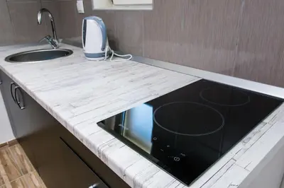 a kitchen with a counter with a sink and a stove at Studio Apartment Dzungla in Doboj