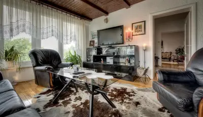 a living room with a table and chairs and a tv at Mott Residence in Tuzla