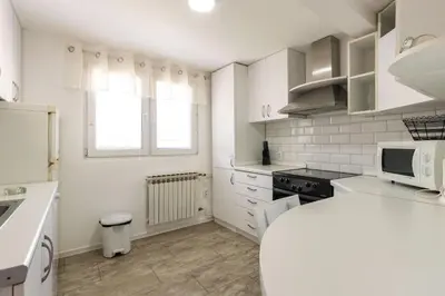 a white kitchen with a sink and a microwave at Mott Residence in Tuzla