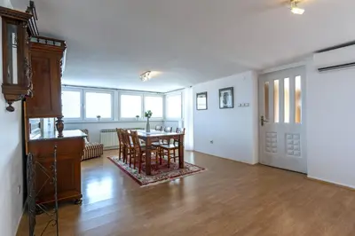 an empty living room with a table and chairs at Mott Residence in Tuzla