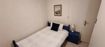 a small bedroom with a blue and white bed at Mott Residence in Tuzla