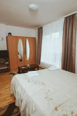 a bedroom with a large white bed and a mirror at Apartman CENTAR 1 in Banja Luka