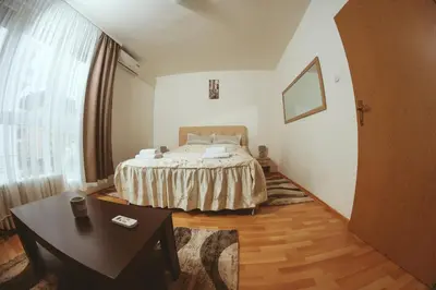 a bedroom with a bed and a table in it at Apartman CENTAR 1 in Banja Luka