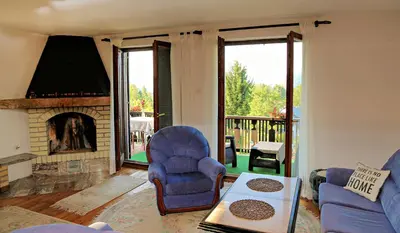 a living room with two chairs and a fireplace at Merak Holiday Home in Visoko