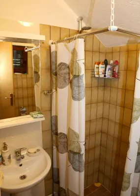 a bathroom with a shower curtain and a sink at Merak Holiday Home in Visoko