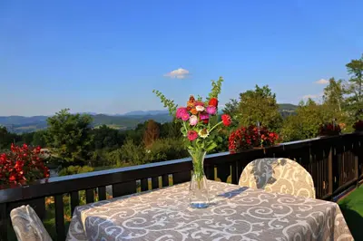 a vase of flowers on a table on a balcony at Merak Holiday Home in Visoko