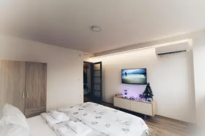 a bedroom with a bed and a tv on the wall at Apartman Srdjan in Banja Luka