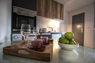 a table with two wine glasses and a bowl of apples at Apartman Srdjan in Banja Luka