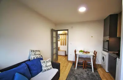 a living room with a blue couch and a table at Apartman Srdjan in Banja Luka