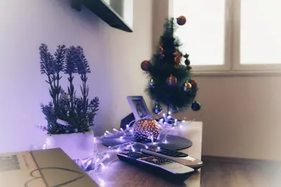 a table with a christmas tree and remote controls at Apartman Srdjan in Banja Luka