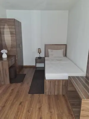 a bedroom with a bed and a wooden floor at Motel HEKO in Bugojno