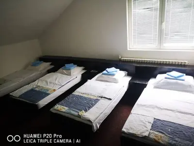 a room with three beds in it with a window at Motel HEKO in Bugojno