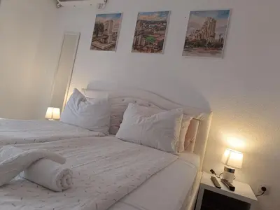a white bedroom with a bed with white sheets and pillows at SWEET APT Zenica in Zenica