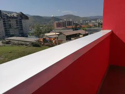 a red and white wall with a view of a city at SWEET APT Zenica in Zenica