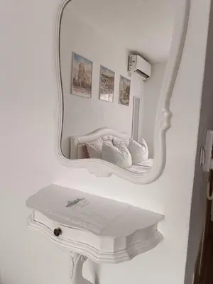 a mirror on a wall with a bed in a room at SWEET APT Zenica in Zenica