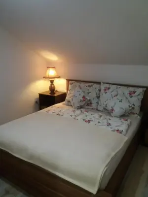 a bedroom with a bed with pillows and a lamp at Edo in Visoko