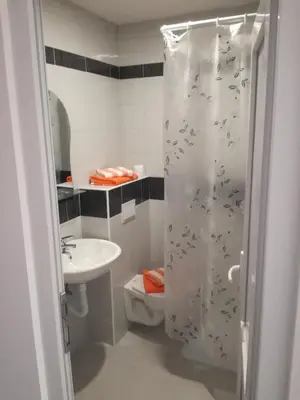 a bathroom with a shower curtain with a toilet and a sink at Edo in Visoko