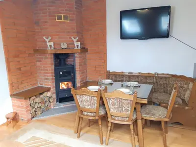 a dining room with a table and a fireplace at Apartman Kupres Centar in Kupres