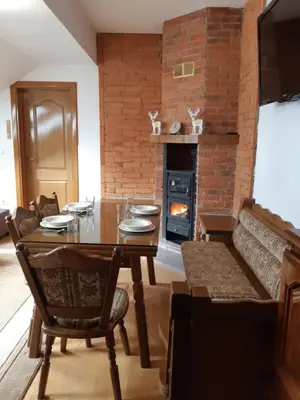 a dining room with a table and a brick wall at Apartman Kupres Centar in Kupres