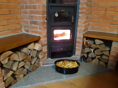 a brick oven with a fire in a brick wall at Apartman Kupres Centar in Kupres