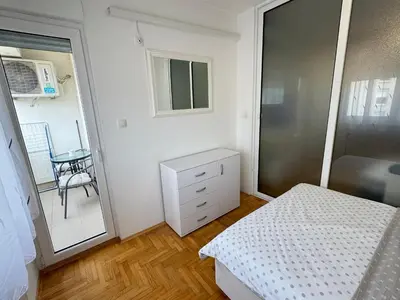 a small bedroom with a bed and a mirror at Apartment 4th. Floor in Banja Luka