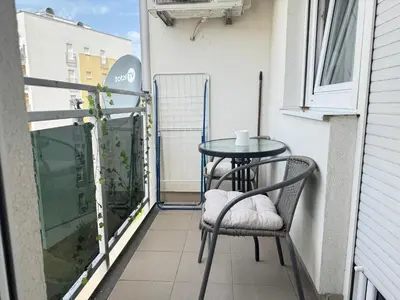 a small balcony with a table and chairs on it at Apartment 4th. Floor in Banja Luka
