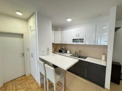 a kitchen with white cabinets and a white counter top at Apartment 4th. Floor in Banja Luka